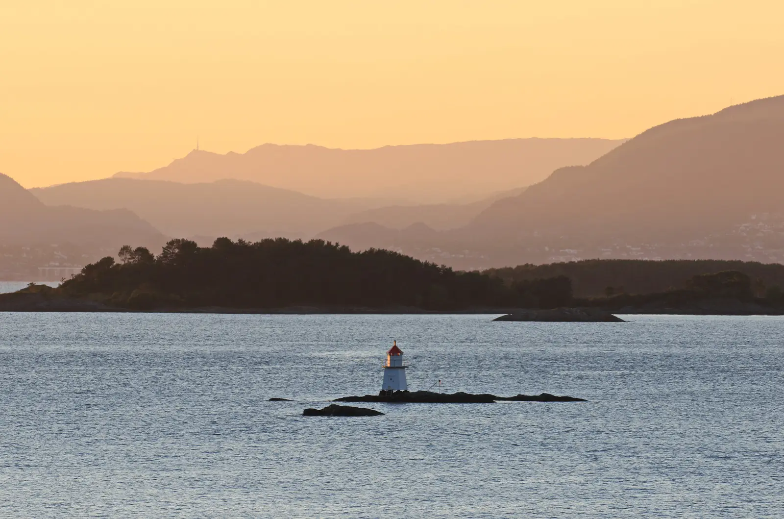 Evening sun over the fjord by Tysnes in Sunnhordland, with a small lighthouse on a skerry